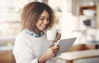 放松快乐无忧无虑的黑色的女人阅读社会媒体新闻咖啡首页微笑非洲美国女享受安静的早....流媒体在线浏览互联网