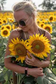 美丽的女人向日葵场日落享受夏天自然有吸引力的金发女郎长健康的头发