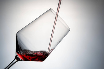 特写镜头填充水晶玻璃红色的酒倒红色的酒水晶玻璃孤立的灰色背景图像减少概念饮料