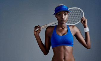 网球部<strong>分工</strong>作室拍摄运动年轻的女人摆姿势网球球拍灰色背景