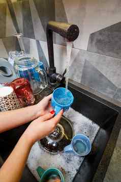 手海绵洗杯水家庭主妇女人洗蓝色的杯子厨房水槽蓝色的海绵手清洁手动做家务洗碗机