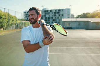 网球肘引起的重复的手腕手臂运动运动年轻的男人。持有肘疼痛玩网球网球法院