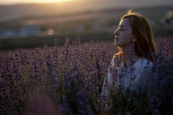 中年女人坐在薰衣草场享受芳香疗法芳香疗法概念薰衣草石油照片会话薰衣草