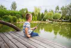 男孩钓鱼湖夏天一天国际孩子们的一天