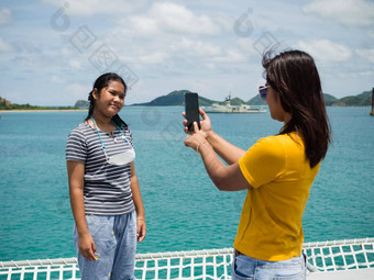 女人黄色的衬衫持有<strong>电</strong>话<strong>图片</strong>女孩灰色的衬衫背景蓝色的水小山旅游<strong>电</strong>晕病毒爆发