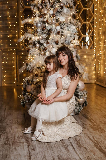 女孩妈妈。光节日礼服圣诞节树主题一年的假期节日室内花环光灯泡
