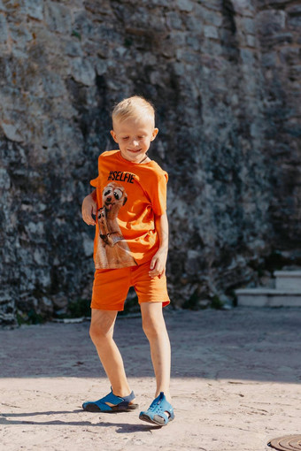 儿童户外活动微笑蹒跚学步的男孩穿橙色短裤跳运行有趣的后院阳光明媚的热夏天一天完整的长度精力充沛的男孩时尚的休闲装跳户外
