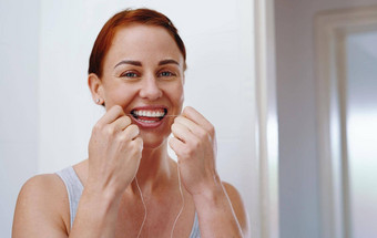 完美的微笑用牙线清洁牙齿<strong>定期</strong>肖像有吸引力的年轻的女人用牙线清洁牙齿牙齿内部浴室首页