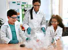 有趣的学习可爱的男孩女孩进行科学实验老师学校
