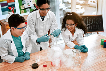 科学实验鼓励探索可爱的男孩女孩进行科学实验老师学校