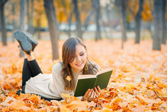 混合比赛女人说谎秋天树叶阅读书秋天公园