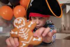 男孩穿着海盗吃骨骼姜饼万圣节戏剧饼干