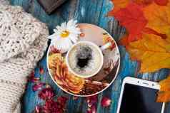 秋天布局杯咖啡橙色叶子干玫瑰花瓣针织毛衣笔记本笔智能手机舒适的工作场所前视图