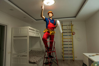 年轻的男人。修复电缆布线安装替换<strong>卤素灯</strong>天花板