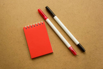 红色的记事本笔记红色的表空白空间笔记灭克磷记号笔红色的黑色的温暖的赭色灰色的背景假期日历笔记记事本