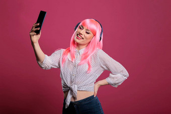 年轻的成人粉红色的头发采取图片记录视频