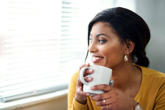 爱早晨有吸引力的年轻的女人坐着喝杯<strong>茶首页</strong>