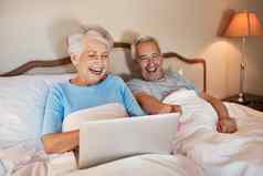 有趣的孙子快乐高级女人移动PC坐着床上丈夫首页