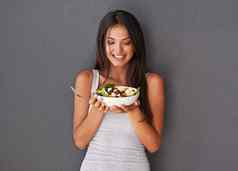 健康的年轻的女吃新鲜的食物沙拉碗微笑美丽的女人持有享受吃清洁绿色饮食菜蔬菜部分素食主义者健康生活方式