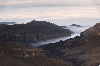 山云日落空中视图多山的岩石范围雾美丽的景观高悬崖天空前视图无人机山谷低云