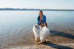 快乐的女人玩白雪公主狗品种日本斯帕斯城市湖
