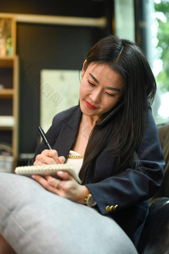 亚洲工作女人电话谈话使笔记笔记本