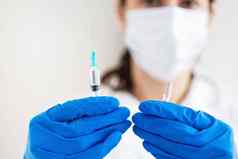 年轻的医生注射器疫苗手医生在室内使疫苗接种女人医疗办公室疫苗接种流感病毒