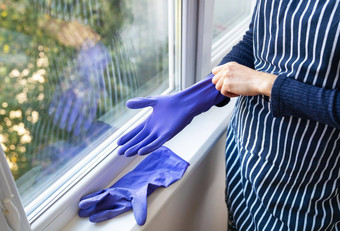 年轻的<strong>女孩</strong>条纹<strong>围裙</strong>把紫色的手套手准备洗窗户公寓房子清洁清洁概念