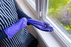年轻的女孩条纹围裙把紫色的手套手准备洗窗户公寓房子清洁清洁概念