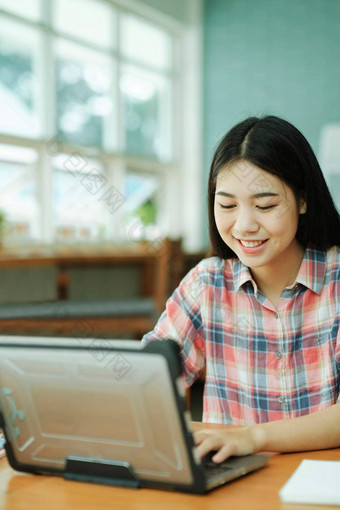 年轻的亚洲女人研究前面移动PC电脑离线