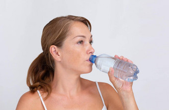 女人喝纯水塑料瓶白色背景