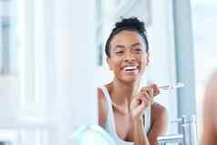 刷更健康的保持有吸引力的年轻的女人刷牙牙齿浴室首页