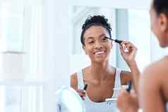 睫毛膏朋友美丽的年轻的女人应用睫毛膏浴室镜子