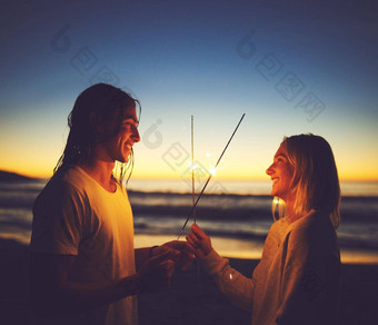 光<strong>我学</strong>爱年轻的夫妇玩罗马焰火筒海滩晚上