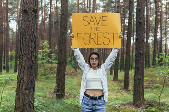 年轻的女人<strong>志愿</strong>者森林雪桩持有<strong>海报</strong>保存森林