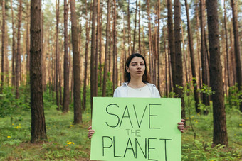 年轻的女积极分子站森林海报保存地球志愿者斗争森林砍伐