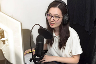 年轻的女人眼镜专业麦克风耳机记录播客工作室技术媒体
