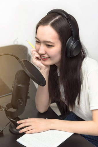 年轻的微笑女人专业麦克风耳机记录播客工作室技术媒体