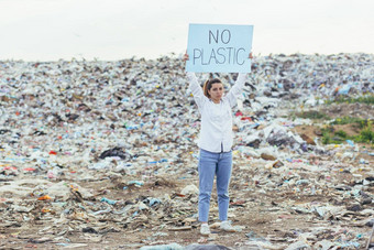 女人垃圾填埋场志愿者持有海报保存地球