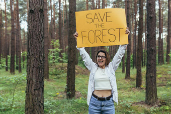年轻的女人<strong>志愿者</strong>森林雪桩持有<strong>海报</strong>保存森林
