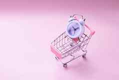 白色报警时钟玩具购物车孤立的粉红色的看购物车缺乏时间购物时间电车钱金融危机购物狂概念购买销售