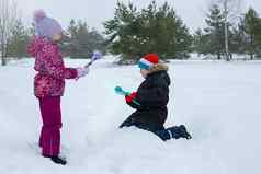 男孩女孩在户外冬天使雪球塑料雕刻工具