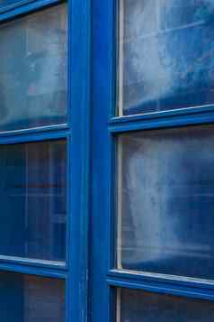 蓝色的木双通过玻璃窗户关闭百叶窗
