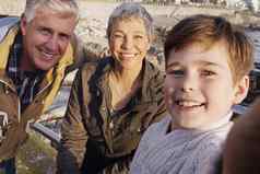 伟大的微笑运行家庭可爱的男孩采取自拍爷爷奶奶海滩