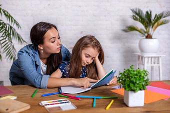 妈妈。沮丧女儿同时家庭作业坐着表格首页学习困难家庭作业