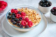 燕麦片树莓黑加仑子压碎坚果玻璃碗健康的平衡食物