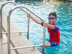 男孩穿游泳护目镜蓝色的池梯红色的泳衣