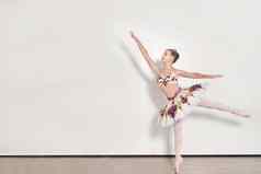 年轻的芭蕾舞女演员执行芭蕾舞练习工作室白色背景