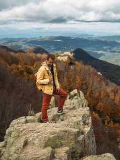 快乐旅行者站岩石享受旅程风景优美的景观视图秋天森林山