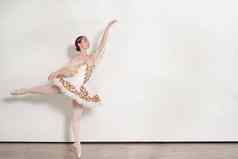 优雅的芭蕾舞女演员执行芭蕾舞练习工作室白色背景